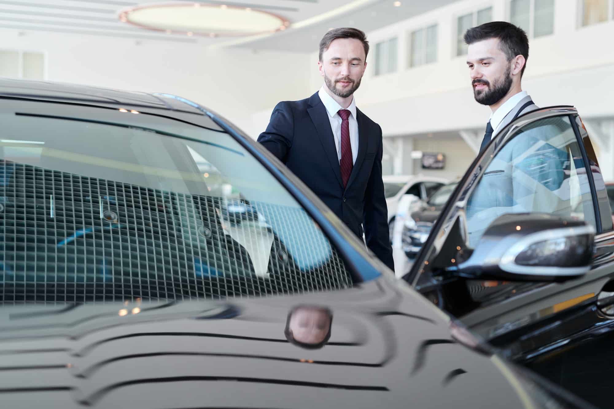 Man choosing a car with car dealer