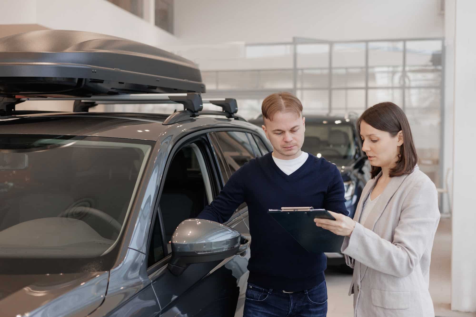 man buys a car at a car dealership and talks to a female sales manager. conclusion of a deal or cont